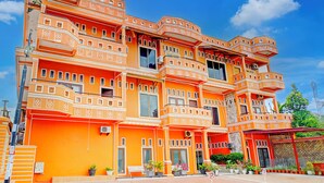 Un immeuble à plusieurs étages doté de balcons, de grandes fenêtres et d’un toit recouvert de tuiles rouges.