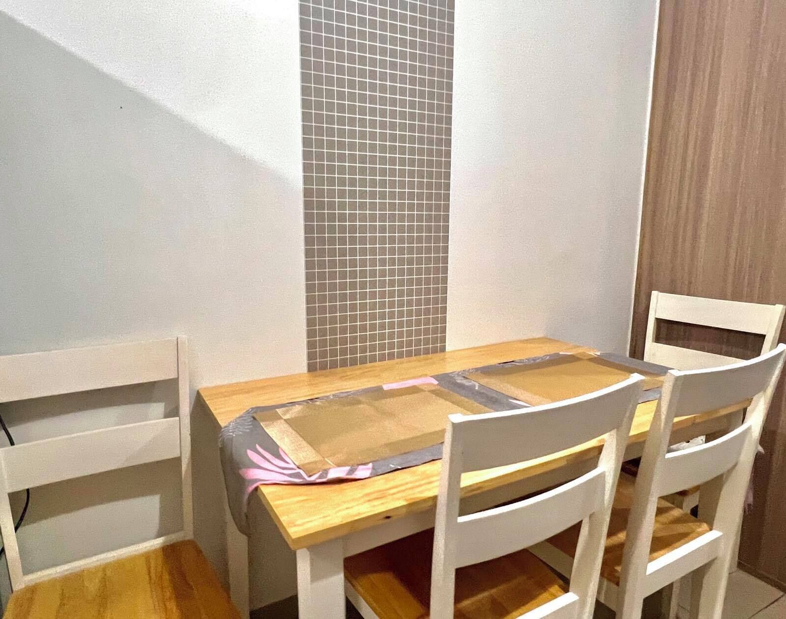 Un comedor con una mesa de madera y sillas blancas.