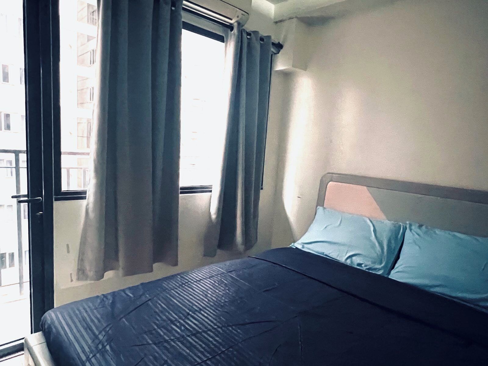 Ein Schlafzimmer mit Bett, Vorhängen und einem Fenster.