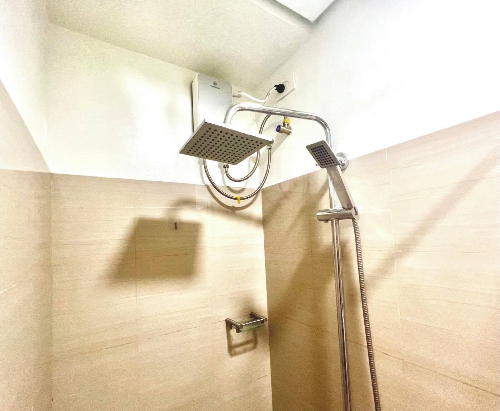 Ducha con cabezal de ducha de mano y otro fijo montado en la pared.