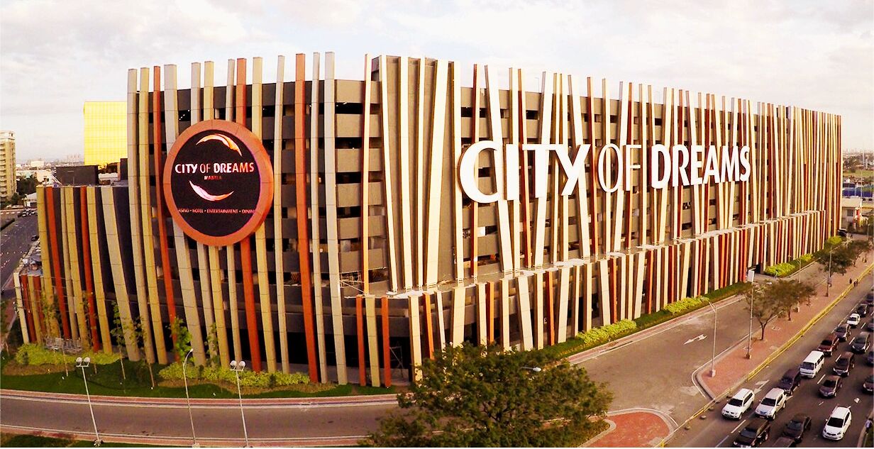 A modern building with the sign "City of Dreams" and a circular logo.
