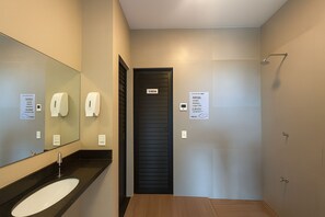 Une salle de bain moderne avec une porte noire, un lavabo et un miroir.