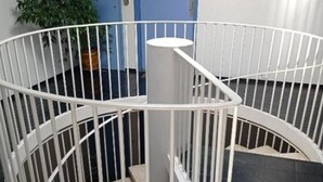 A spiral staircase with white railings in a room with black flooring. - Large Apartment With VIEW OF THE SEA AND CAP Canaille - free parking (Cassis)