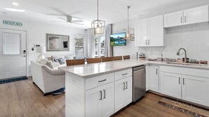 A modern kitchen with white cabinetry, a central island, and a built-in dishwasher.