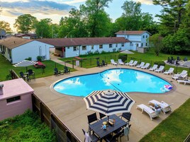 Una piscina al aire libre de temporada, sillones reclinables de piscina