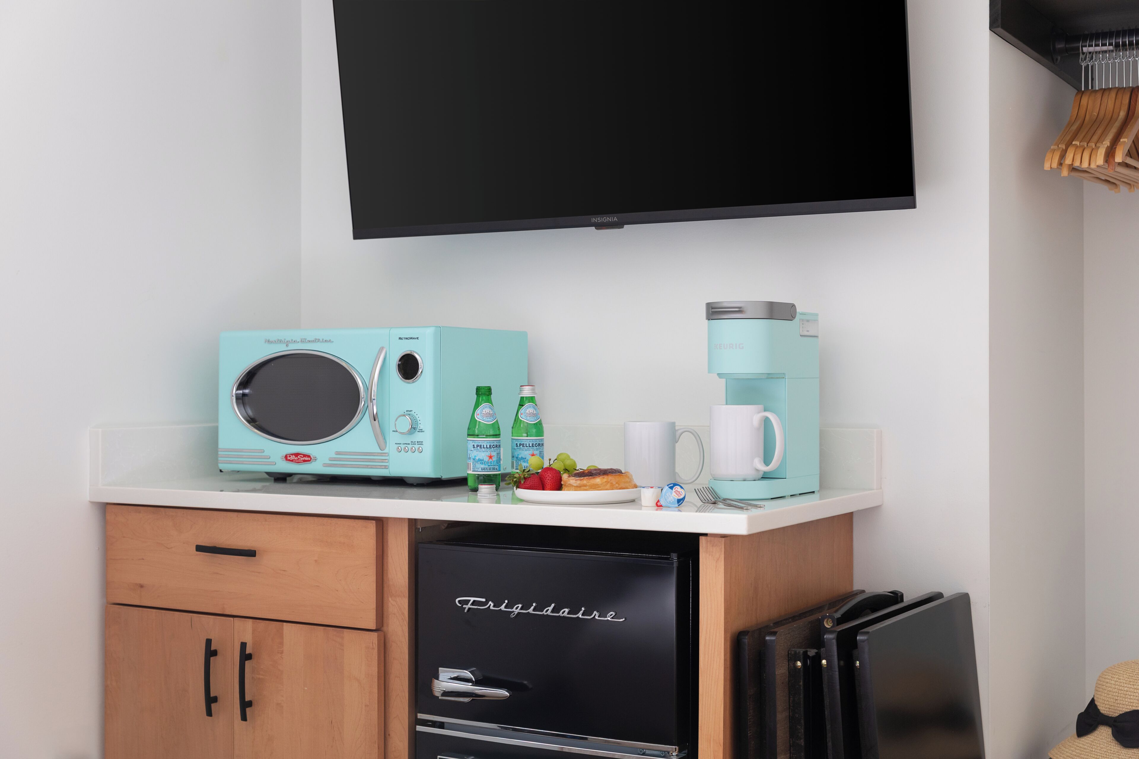 A kitchenette with a microwave, coffee maker, and a refrigerator.