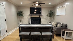 A modern kitchen with a central island, bar stools, a ceiling fan, and a fireplace. - RANCH RETREAT, Beautiful 3-bedroom house in Columbus, MS (Columbus)