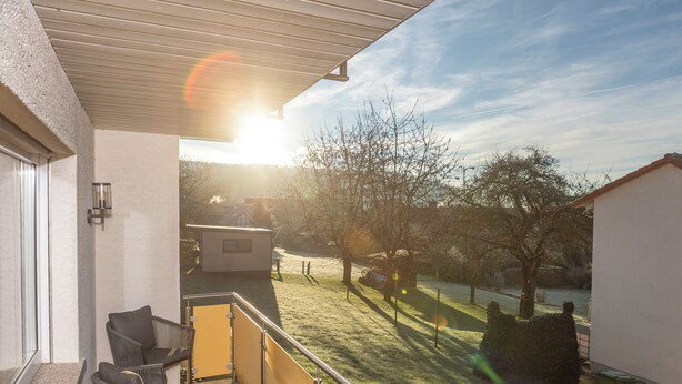 A balcony with a view of a grassy yard and trees. - Apartment MiA Cozy apartment near the Edersee and National Park (Frankenau)