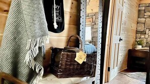 Ein gemütliches Zimmer mit einer Holzbank, einem Hängesessel, einem Korb und einem Spiegel an der Wand.