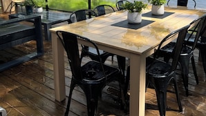 Eine Holzterrasse mit Tisch und Stühlen mit Blick auf einen See.