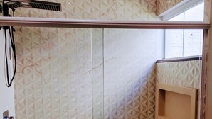 Een badkamer met patroon betegelde vloer, een douchegedeelte en een raam.