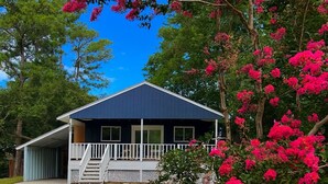A single-story house with a dark blue exterior and a white porch. - Wavy Navy - 2 Queen Beds - Centrally Located - Kill Devil Hills OBX (Kill Devil Hills)