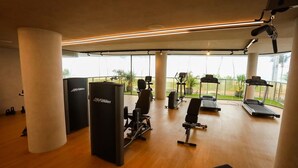 Ein Fitnessraum mit Cardiogeräten, Krafttrainingsgeräten und einer Bank.