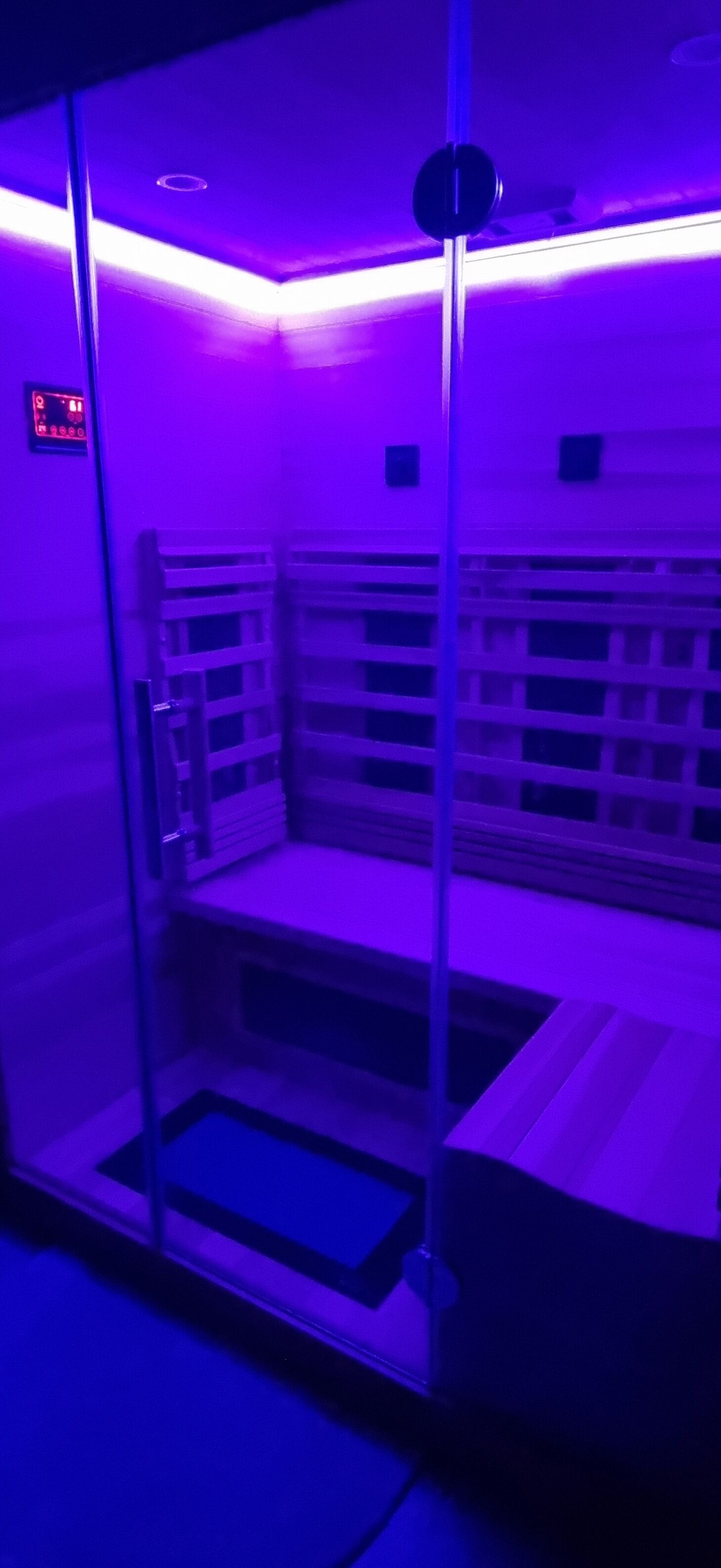 A room with a glass partition, a bench, and a ceiling light fixture.