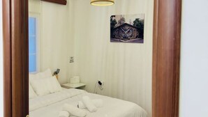A bedroom with a bed, a bedside table, a lamp, and a ceiling light.