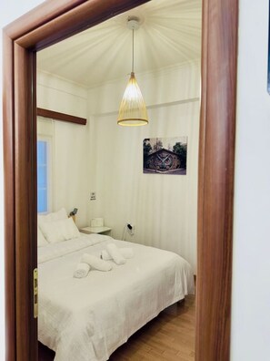 A bedroom with a bed, a bedside table, a lamp, and a ceiling light. - Eclectic Studio Exarcheia for 2 (Athina)
