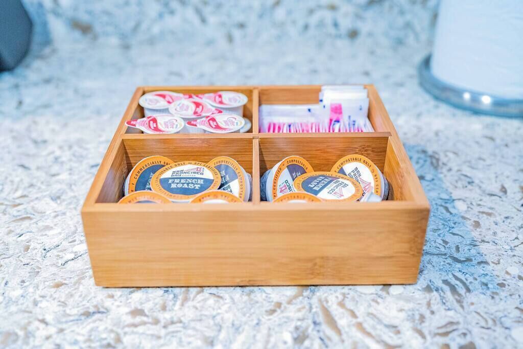 Una caja de madera con divisiones que contienen varios objetos.