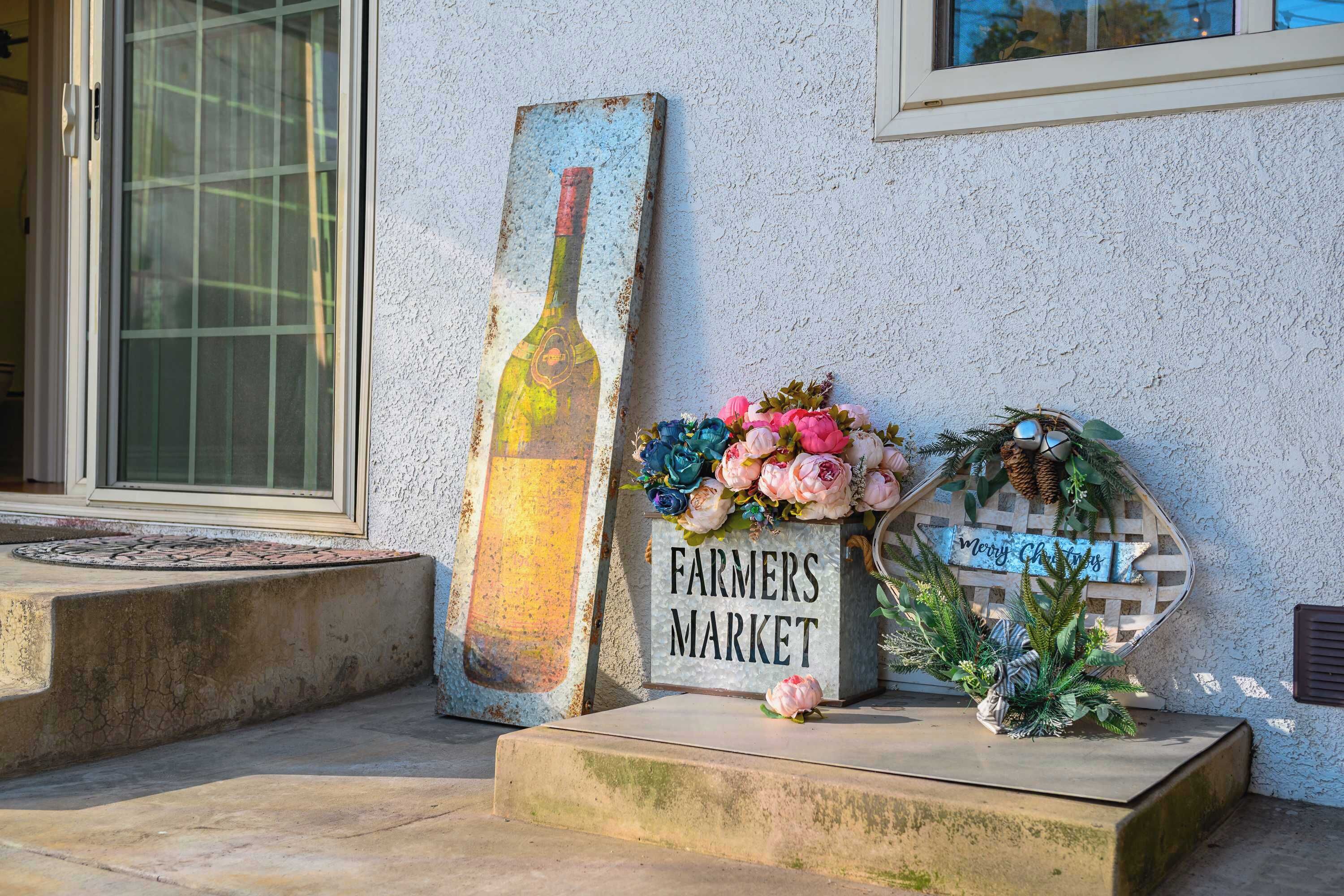 A concrete planter with a sign reading "Farmers Market" and a decorative wreath.