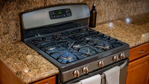 A kitchen with a gas stove, oven, and granite countertop. - Modern Luxury in San Gabriel Valley Retreat (Glendora)
