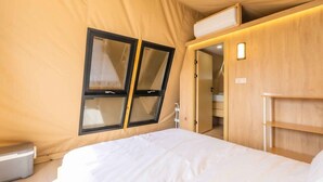 A bedroom with a bed, a window, and a wooden wardrobe. - Urban Glamping Oasis: Comfort & Adventure Combined (Glendora)