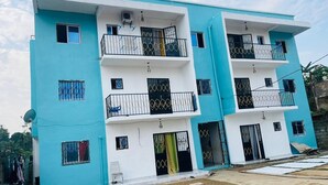 A two-story residential building with balconies, satellite dishes, and a gated entrance. - Douala_yassa_meublé (Douala)