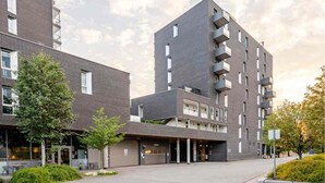 A modern multi-story building with a flat roof, large windows, and a central entrance. - Spacious 3-bedroom with 3 balconies, 2 bthrms, sea view and free indoor parking (Oslo)