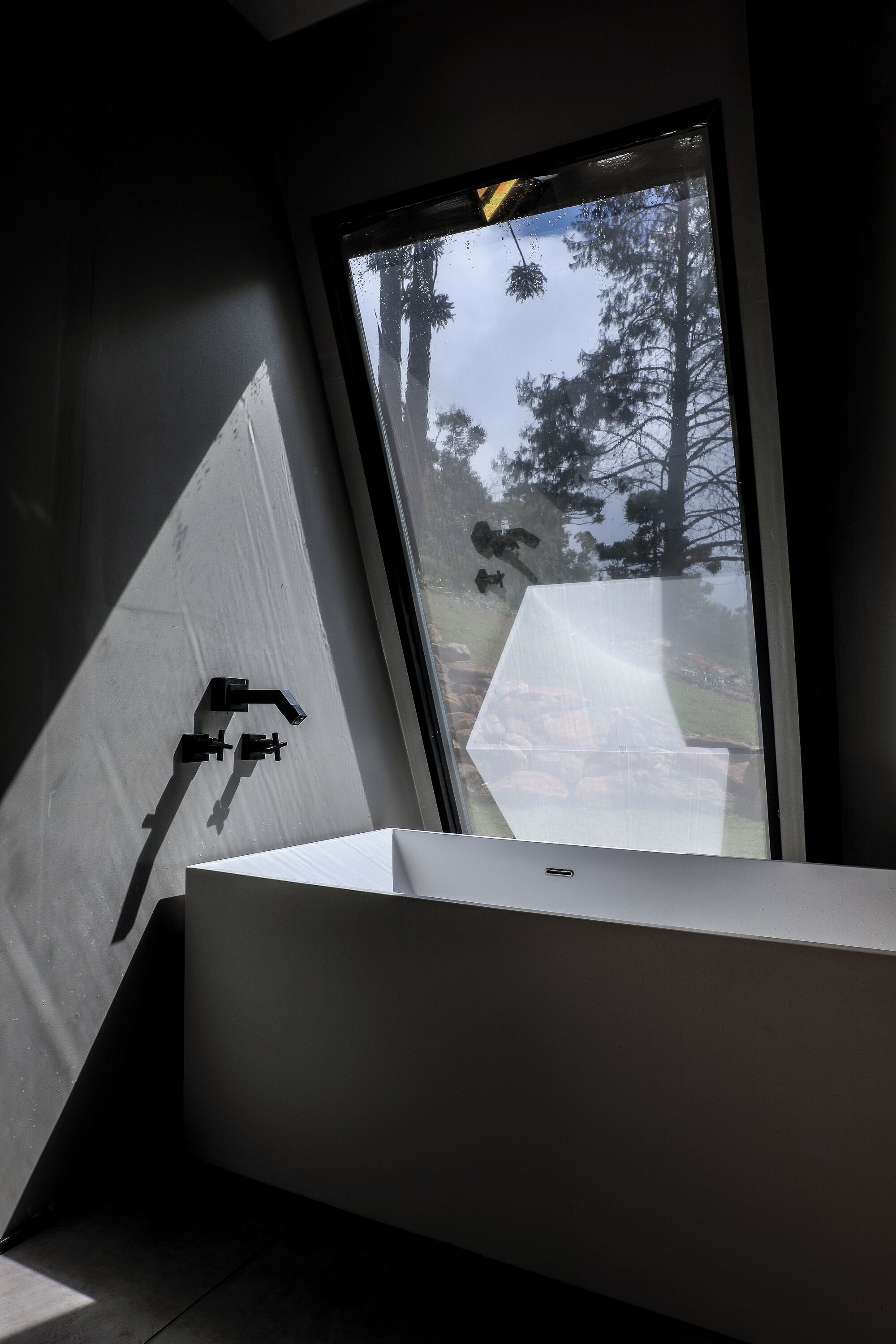 A modern bathroom with a large window, a white sink, and a towel rack.