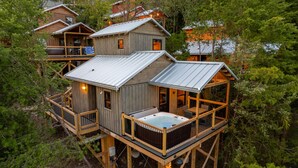 A wooden cabin with a hot tub, deck, and multiple levels.