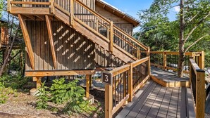 A wooden deck with a staircase leading to a building with a number '3' sign.