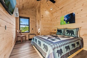 Een houten kamer met een bed, een bureau en een raam.