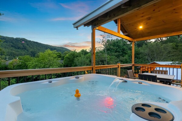 A hot tub with a view of a forested landscape. - Little Forge TreeLodge, Downtown Pigeon Forge (Pigeon Forge)