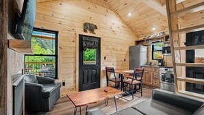 Interior acogedor de una cabaña con comedor, cocina y zona de estar.