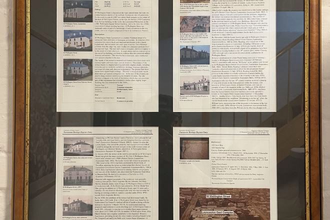 Un panel informativo enmarcado con texto e imágenes de edificios, presumiblemente describiendo características arquitectónicas o información histórica.