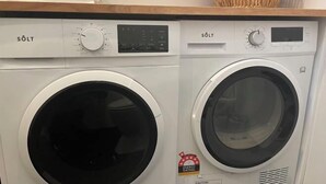 A front-loading washing machine and dryer side by side. - Urban Nook Serviced Apartments (Launceston)