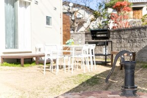 A patio with a table and chairs, a grill, and a water pump. - Shizukinosato Tsuki Terrace 531 (Awaji)