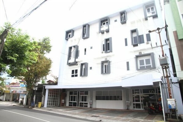 A multi-story building with a white facade and multiple windows. - Istanaku Hotel Manado (Wenang)