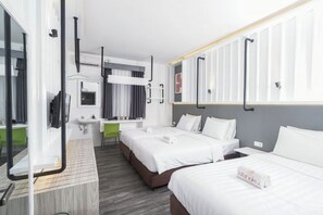 A hotel room with two beds, a desk, a mirror, and a window with curtains. - Istanaku Hotel Manado (Wenang)