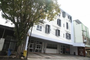 A multi-story building with a flat facade, large windows, and a visible entrance. - Istanaku Hotel Manado (Wenang)