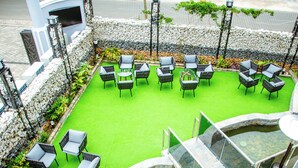 A rooftop garden with outdoor seating and a small water feature. - Wils Hotel SUpreme (Lusaka)