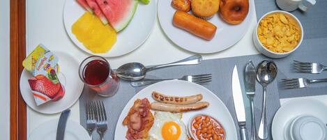 A breakfast spread with various dishes including eggs, sausages, and fruits.