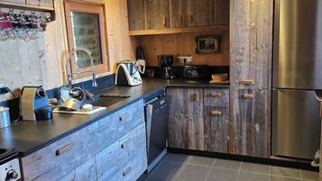 A kitchen with wooden cabinets, a stainless steel refrigerator, a dishwasher, and a coffee maker.