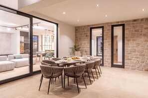 A dining area with a stone wall, a large window, and a modern interior design.
