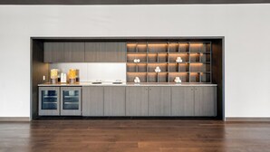 Una cocina moderna con armarios empotrados, una encimera y un mueble de estanterías integrado decorado con objetos.