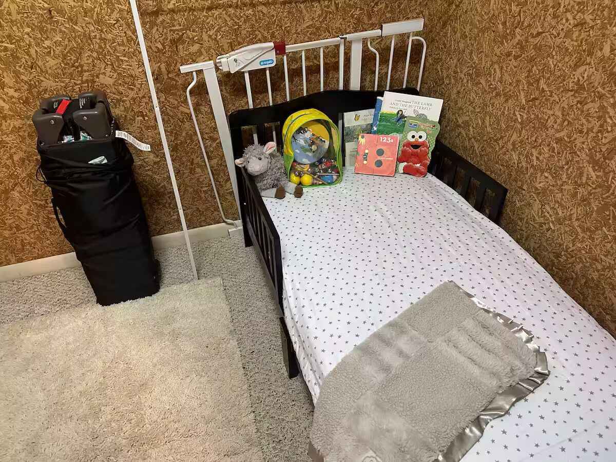 A child's bedroom with a crib, a stuffed animal, and educational toys.