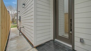 Et rent, moderne hus med hoveddør, en lille veranda og sti til indgangen.