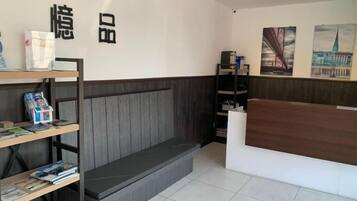 A reception area with a reception desk, a bench, and a bookshelf with magazines.