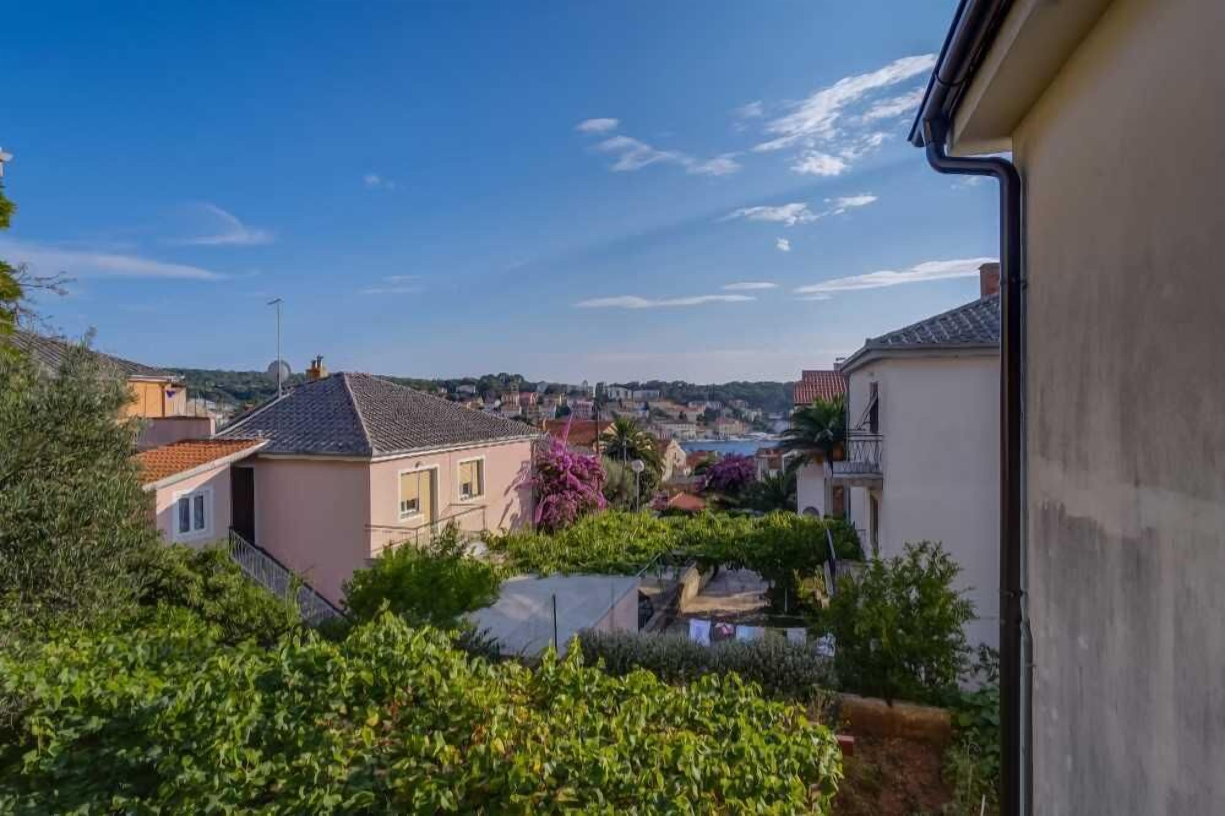 A residential area with houses, greenery, and a clear sky.