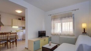 A compact living space with a kitchenette, a dining area, and a bedroom. - Cozy 1BR Suite for Three, No Pets, Parking Available (Mali Lošinj)