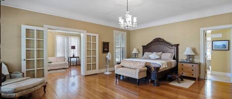 Un dormitorio espacioso con una cama grande, una zona de estar y un vestidor.