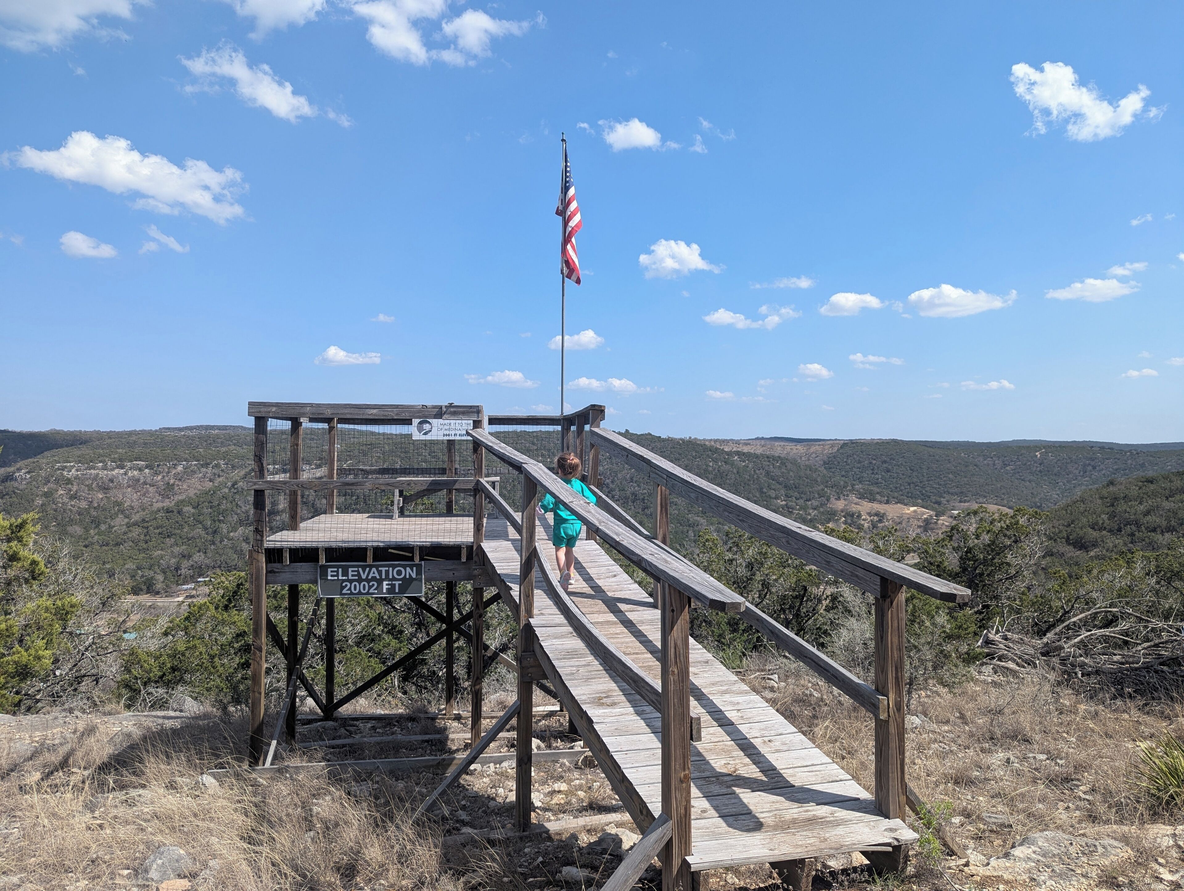 A wooden observation deck with a sign indicating an elevation of 2002 ft.